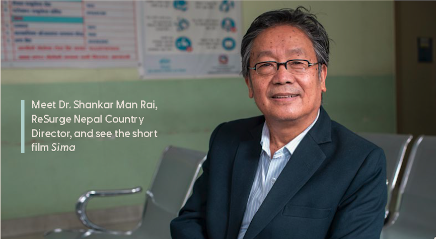 A man in a suit and glasses sits smiling in a waiting area. Text reads: “Meet Dr. Shankar Man Rai, ReSurge Nepal Country Director, and see the short film Sima.” Clinic posters are on the wall behind Dr. Shankar Man Rai as he waits.