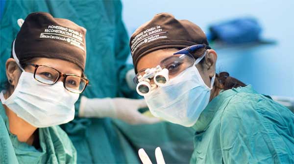 Two surgeons wearing surgical masks and goggles
